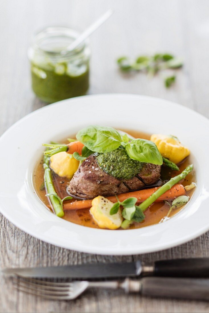 Beef fillet in broth with vegetables and pesto