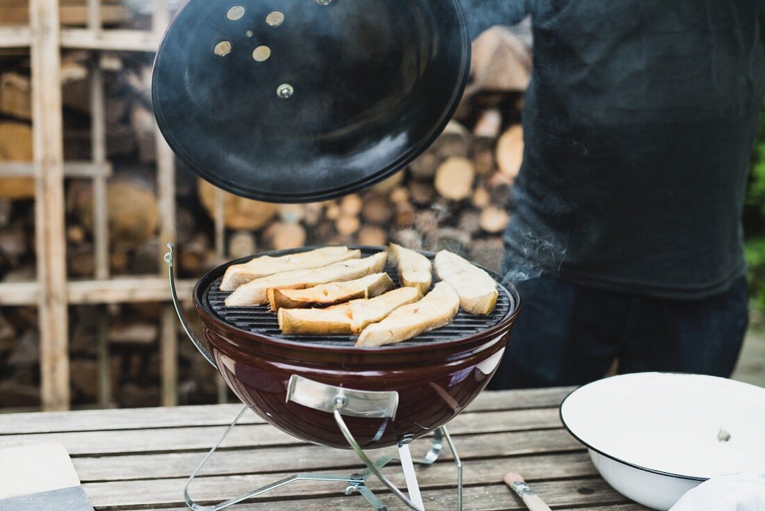 Halibut steaks being smoked in a kettle grill