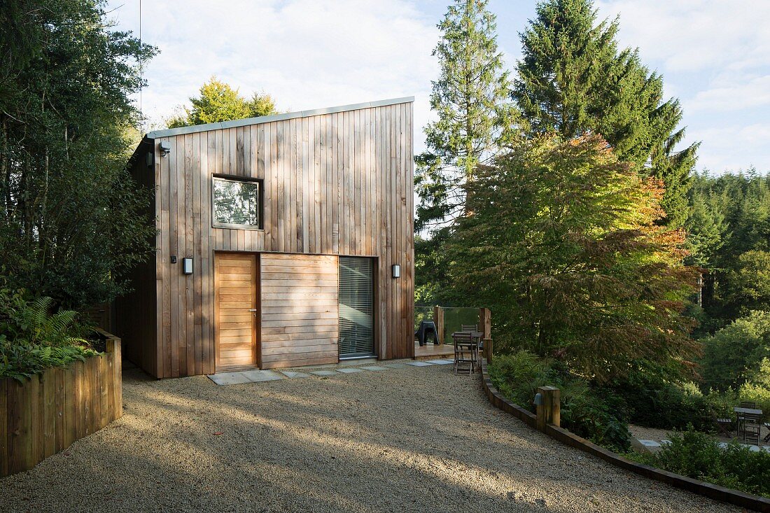 Gekiester Vorplatz und Blick auf zeitgenössisches Wohnhaus aus Holz