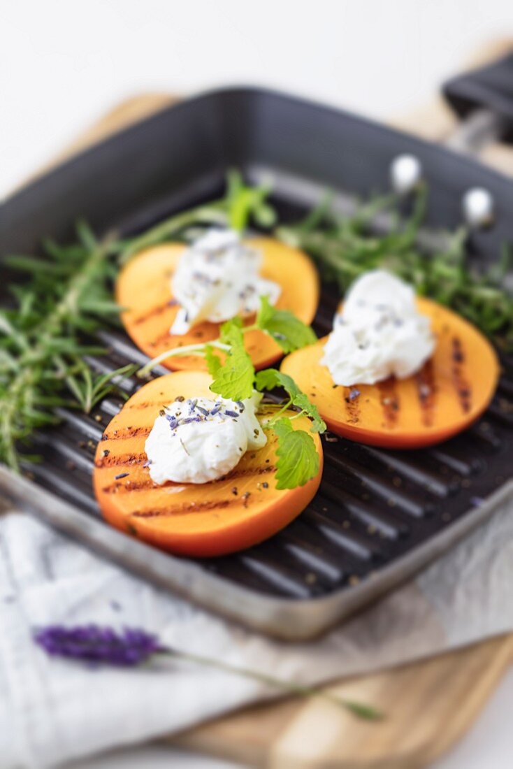Grilled persimmon with goat's cheese cream and herbs