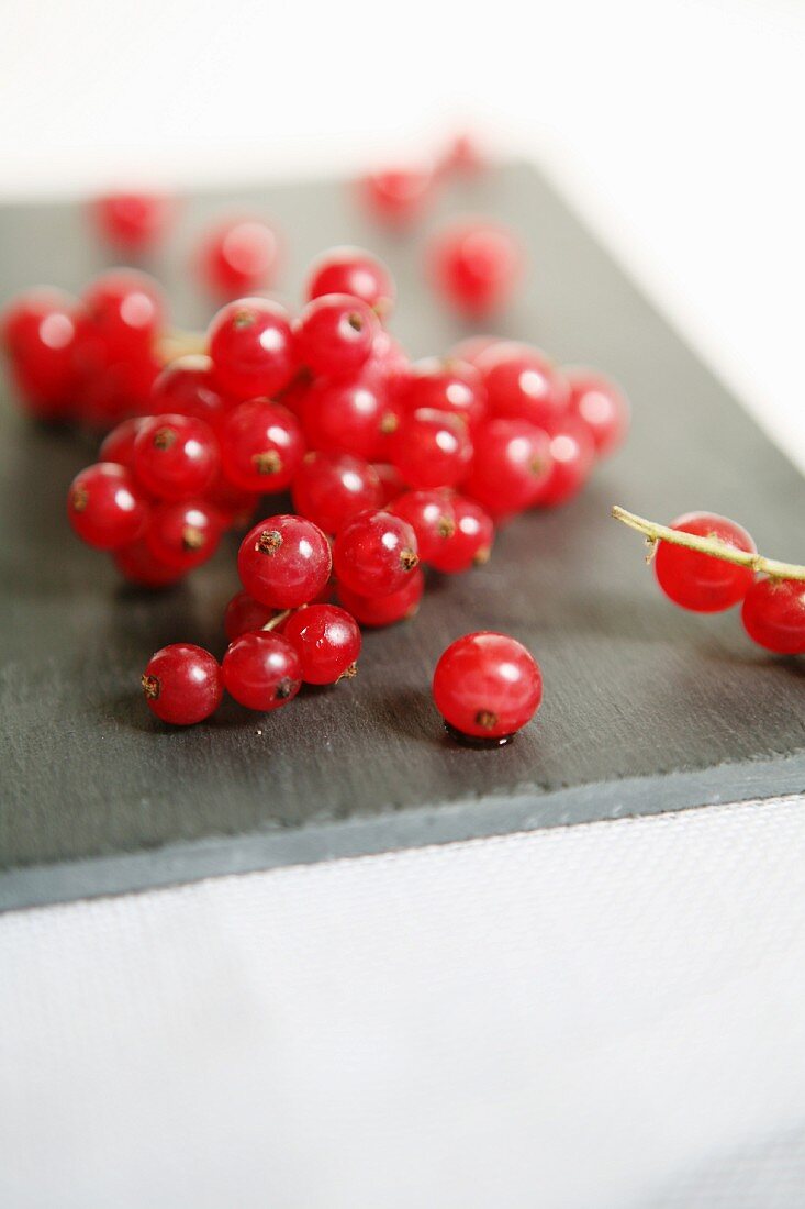 Rote Johannisbeeren auf grauem Brett