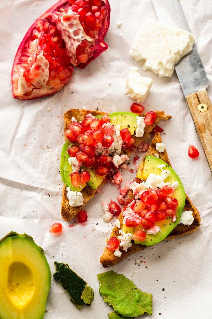 Wholemeal bread triangles with avocado, feta cheese and pomegranate seeds