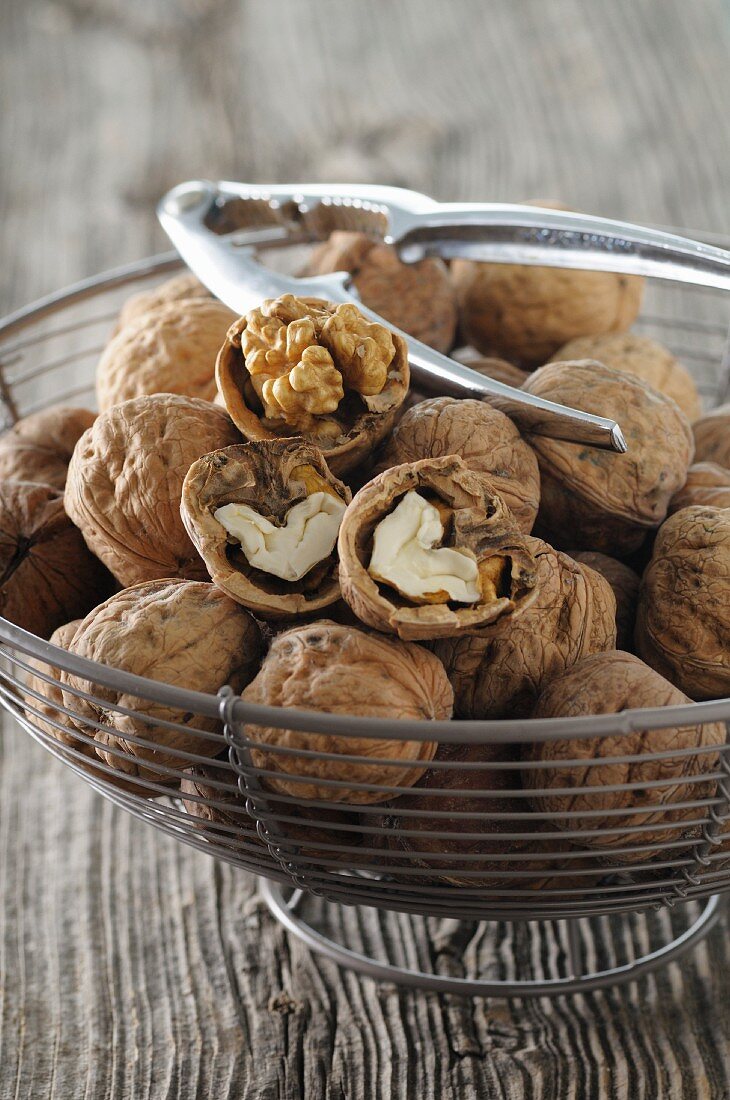 Walnuts with a nutcracker in a wire basket