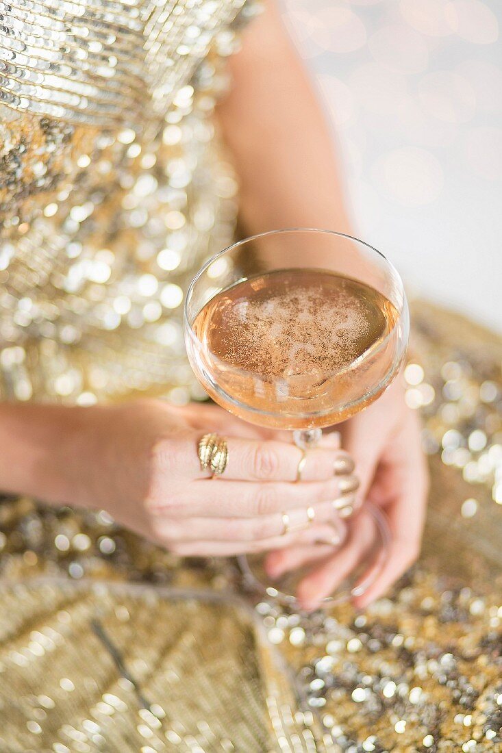 A woman holding a glass of rosé Christmas punch