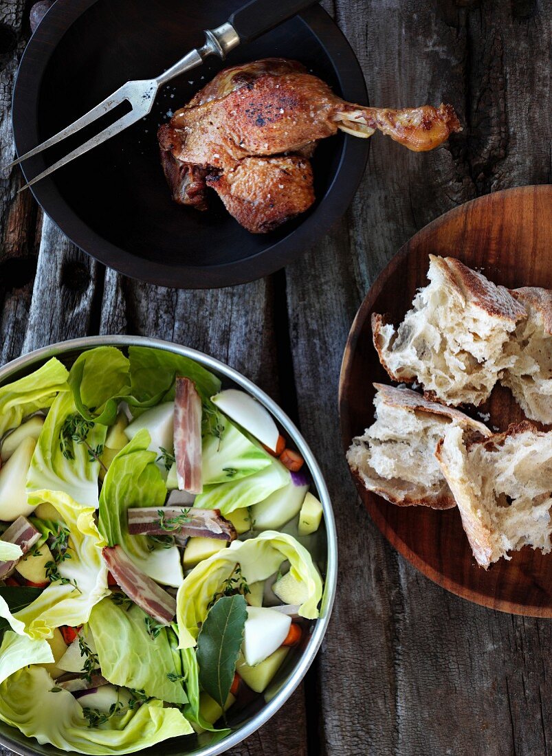 A cabbage medley with bacon, roast chicken and bread