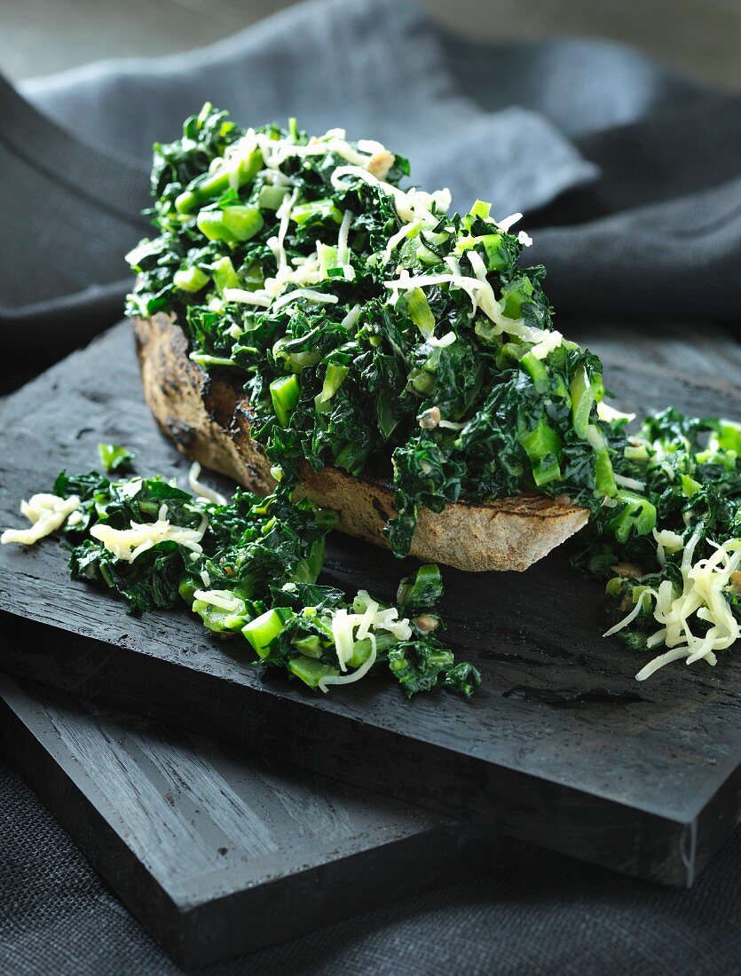Crispy grilled bread with green kale and cheese