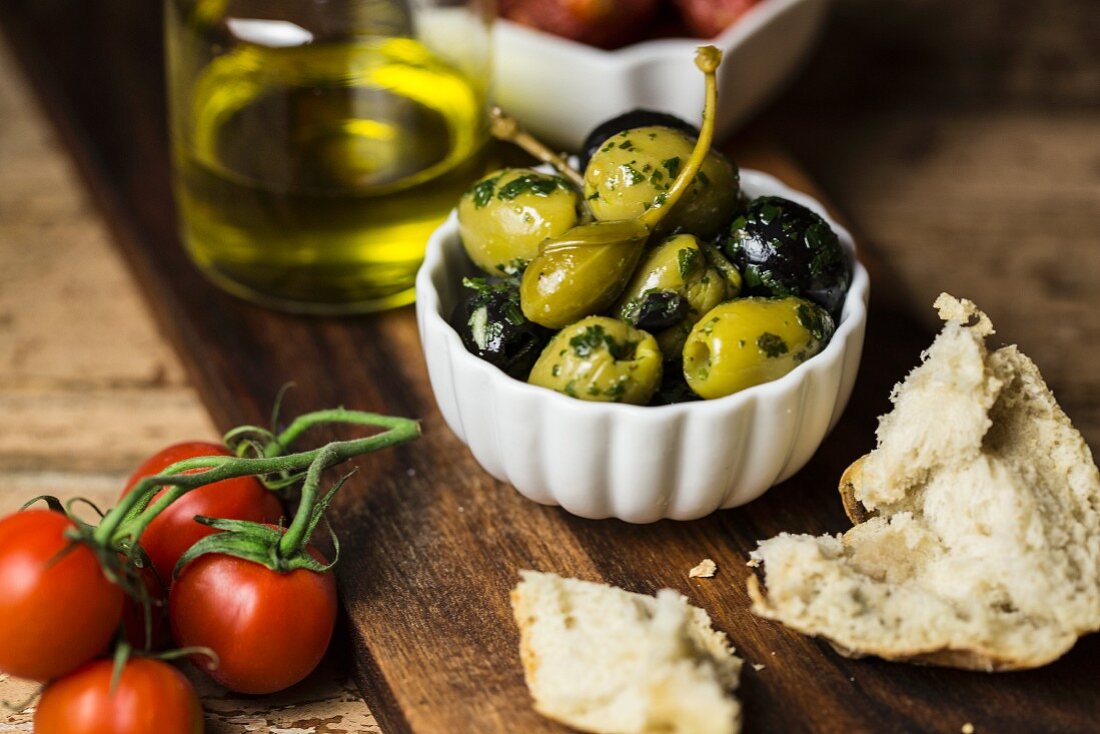 Herb olives, caper fruits, tomatoes and bread