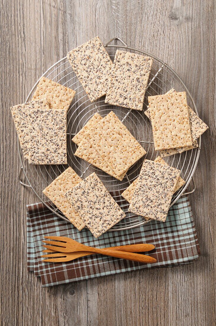 Crackers with sesame seeds and poppyseeds on a cooling rack (seen from above)