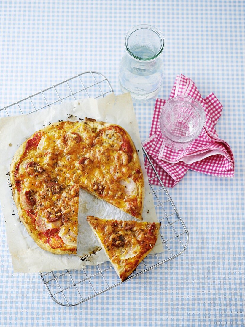 Pizza mit Tomaten und Mozzarella, angeschnitten