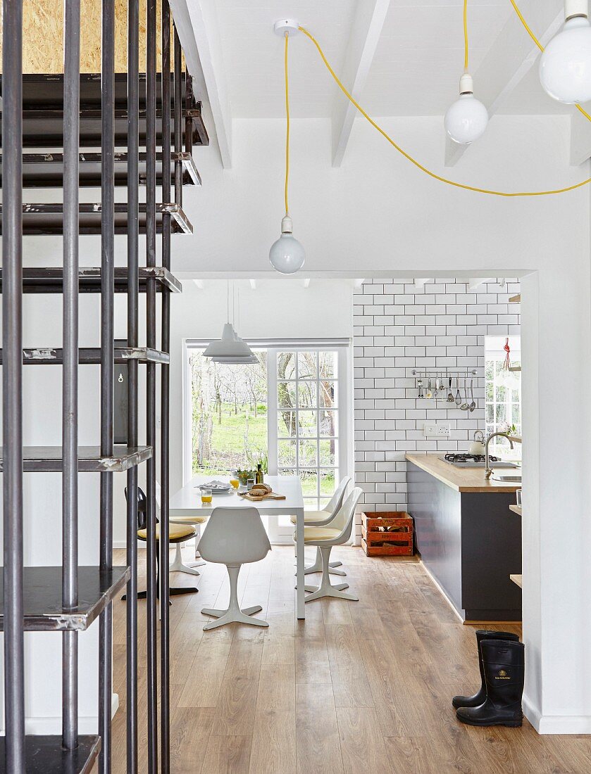 View past steel staircase through open doorway to dining area in front of terrace doors