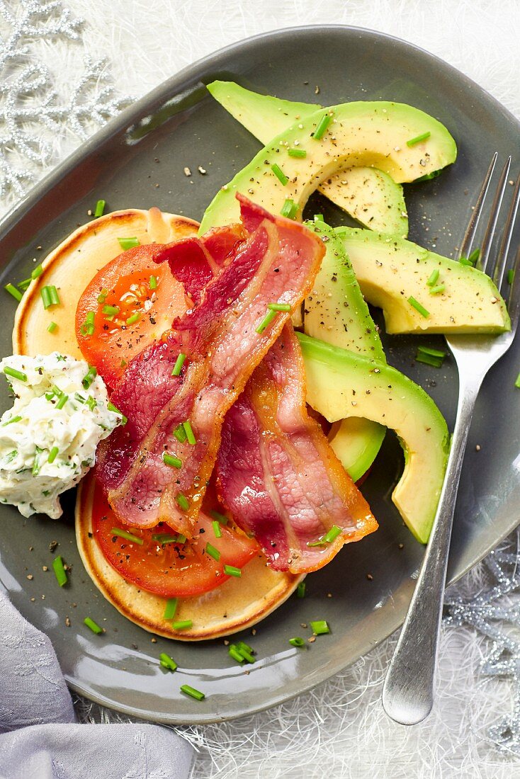 Pancakes with bacon, tomatoes and avocado