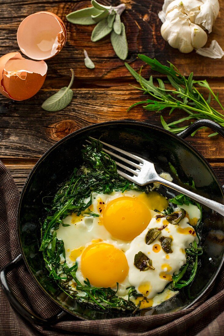 Fried eggs with rocket, yoghurt and chilli