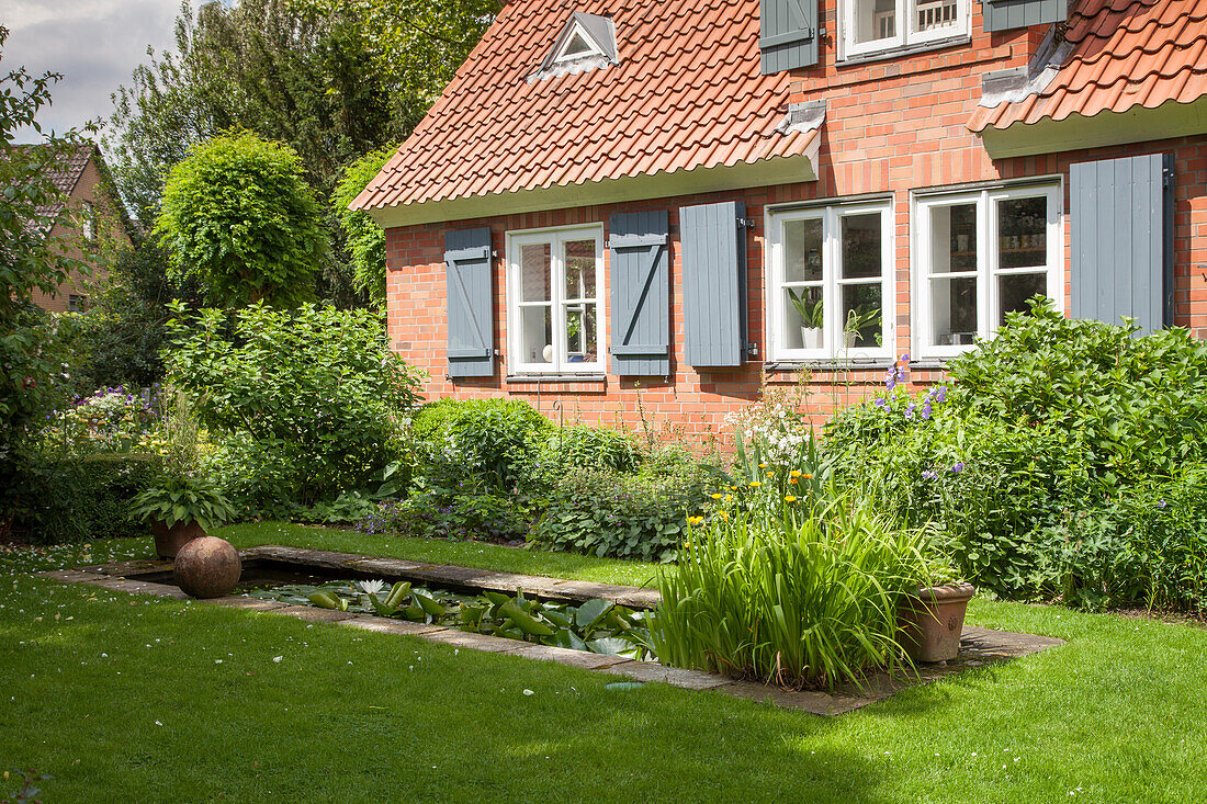 Backsteinhaus mit rechteckigem Gartenteich