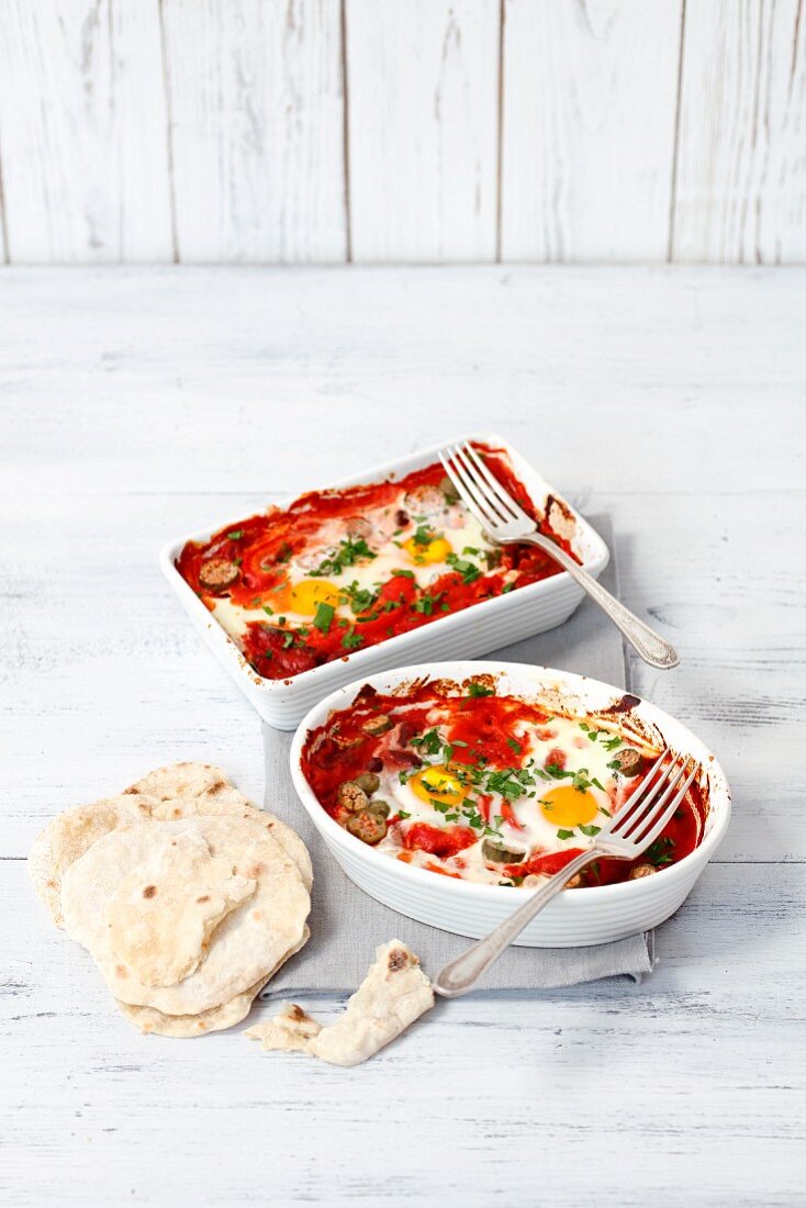 Oven-baked eggs in tomato sauce with peppers and tortillas