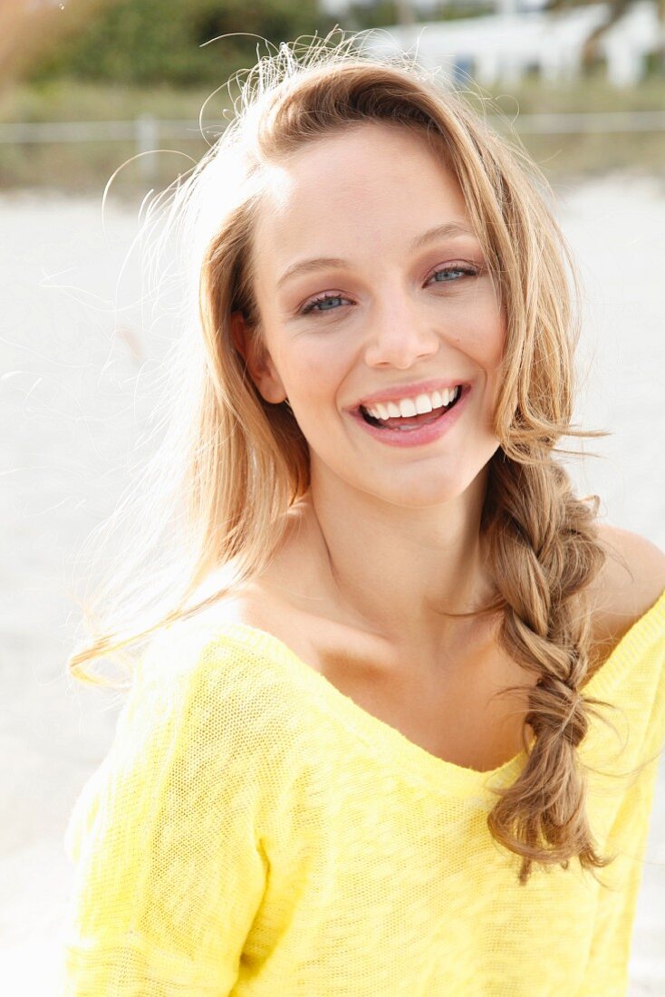 A young blonde woman wearing a yellow jumper