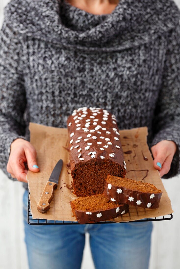 A woman holding gingerbread with chocolate glaze and sugar stars