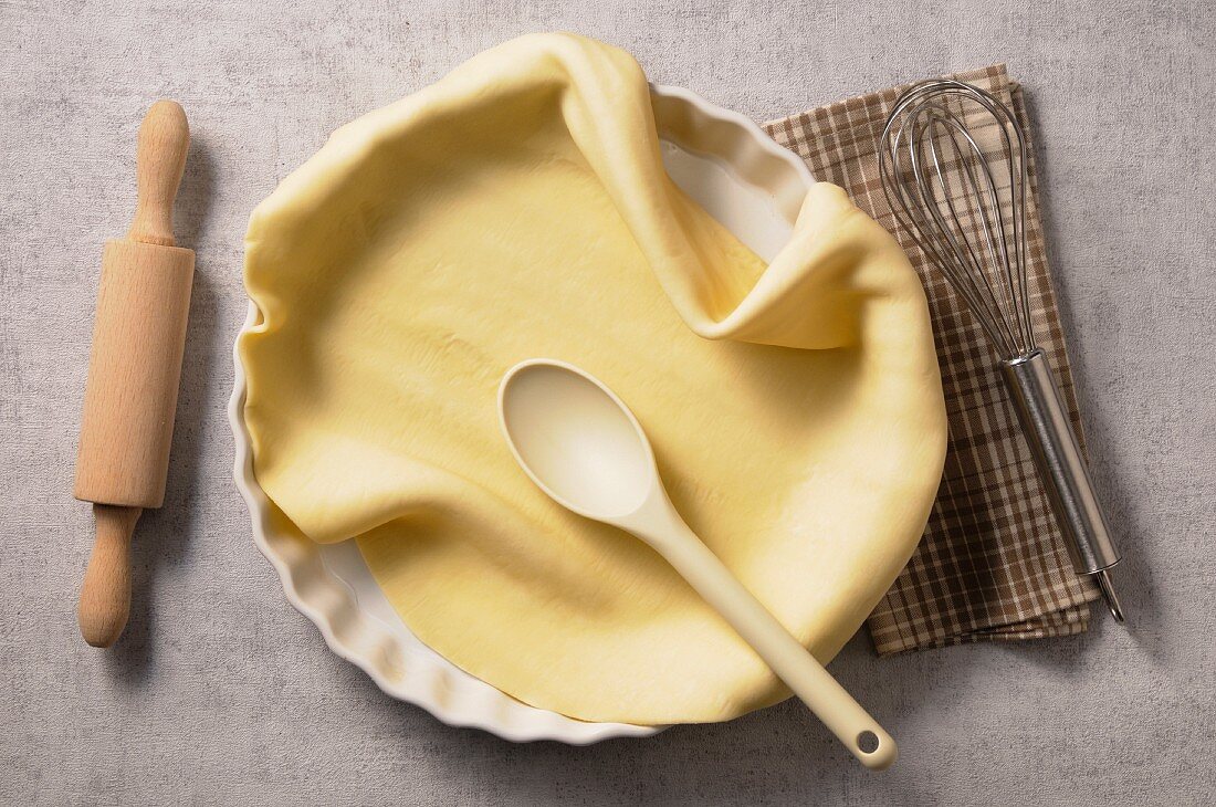 Pastry in a tart dish with a wooden spoon