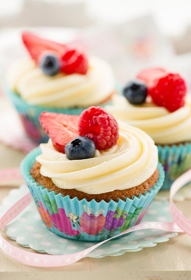 Cupcakes mit Buttercreme und frischen Beeren