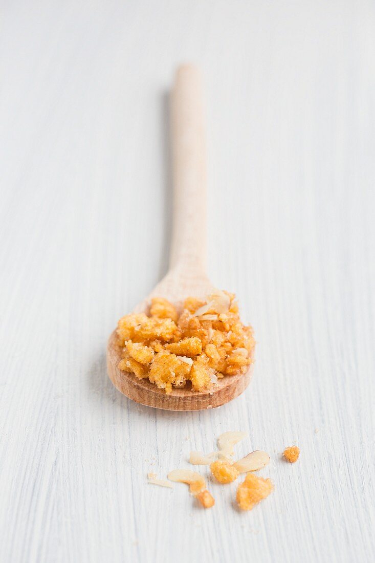 Dried apple pieces with cinnamon, sugar and hazelnuts on a wooden spoon