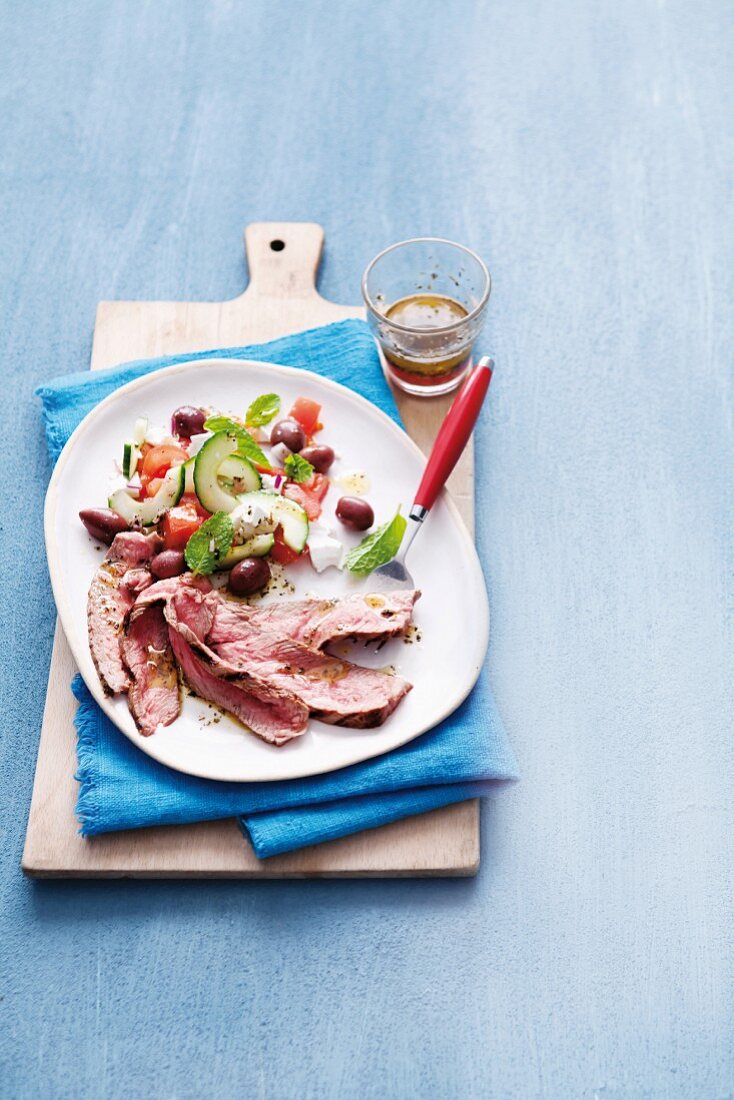 Griechischer Salat mit dünnen rosa Steakscheiben