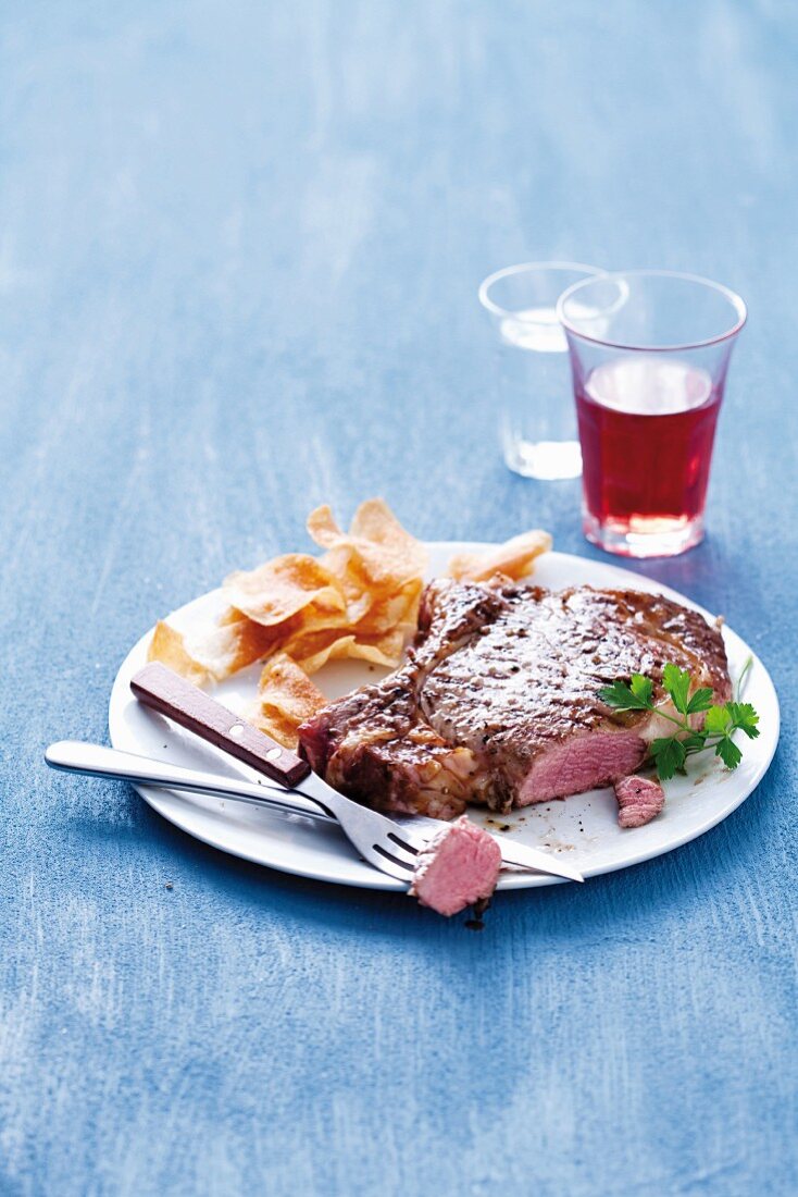 A medium roasted prime rib steak with potato chips