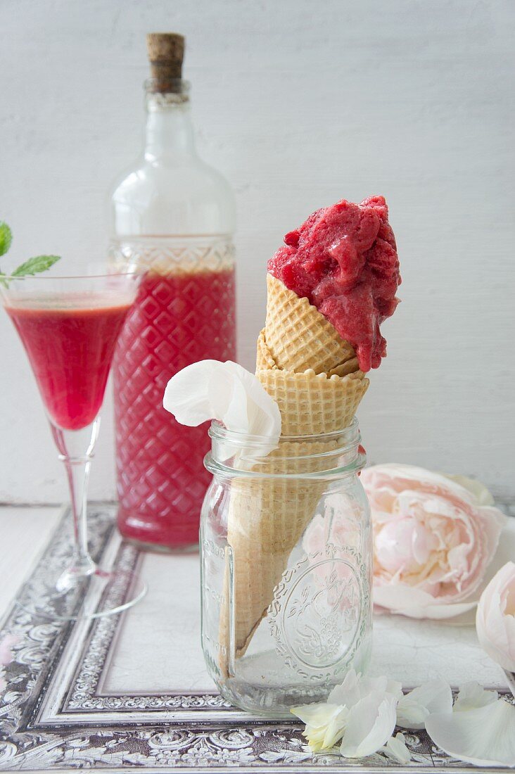 An ice cream cone with raspberry ice cream and home-made raspberry liqueur