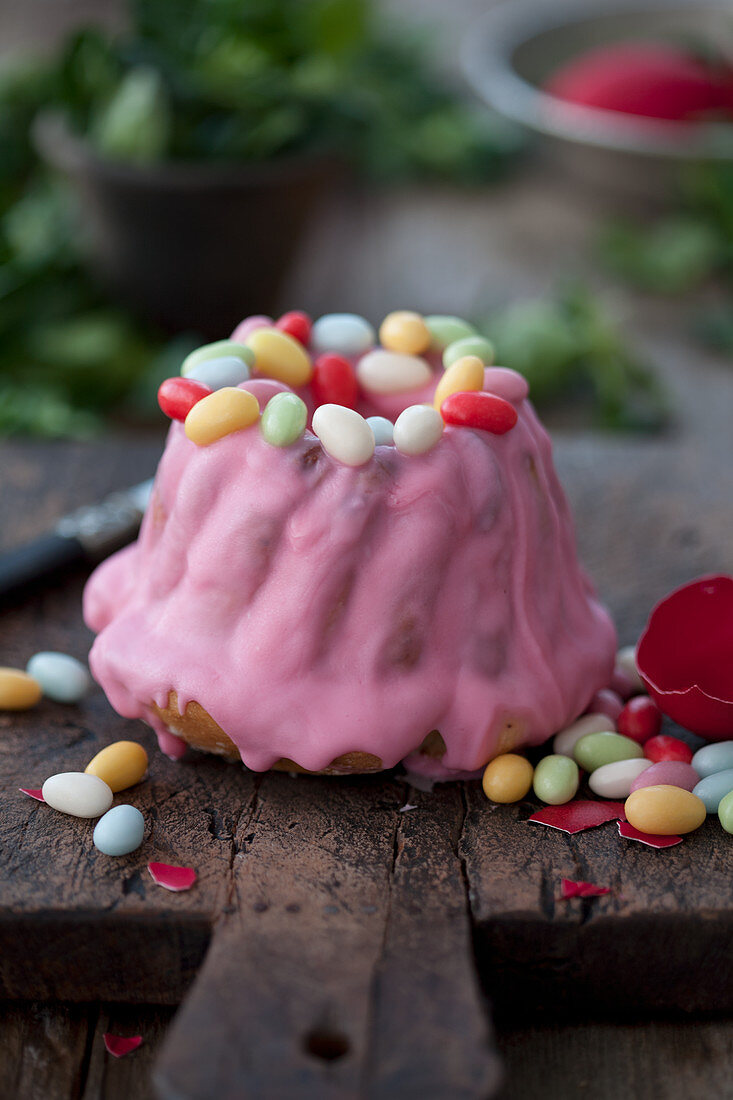 A gugelhupf with pink frosting and sugar eggs