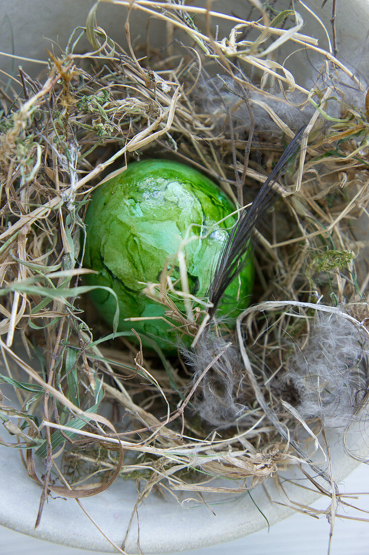 Green Easter eggs in hay nest
