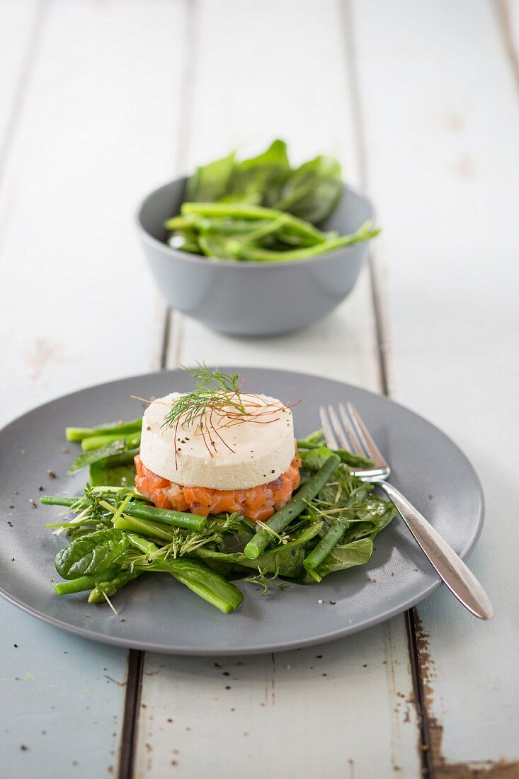 Salmon tatar with horseradish foam on green vegetables