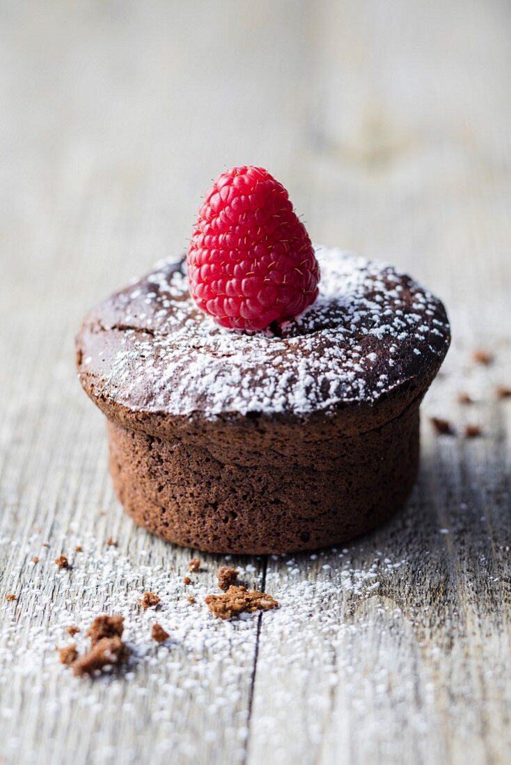 A gluten-free chocolate muffin decorated with a raspberry