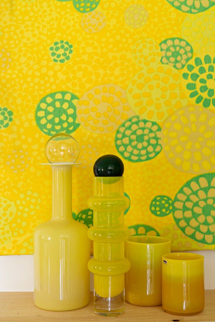 Gelbe Glasvasen vor einem gelben Bild mit Kreisen