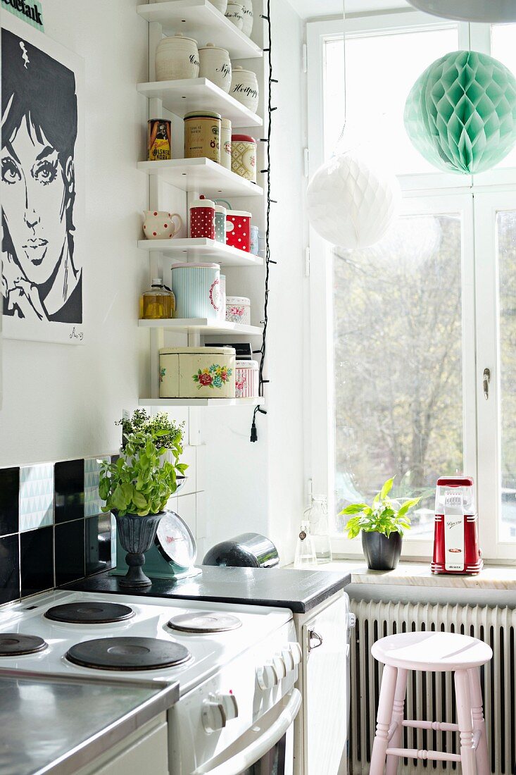 Küchenecke mit schwarz-weißem Pop Art-Poster und weißen Wandboards mit Vintage Aufbewahrungsdosen