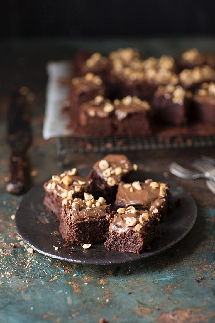 Brownies with nuts on a plate and on a cooling rack