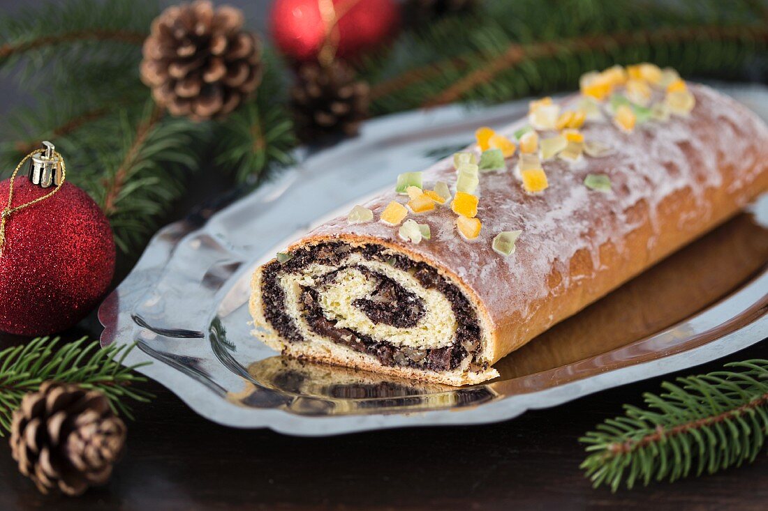 Traditional poppy seed roll cake with icing, dried fruits and nuts (Poland)