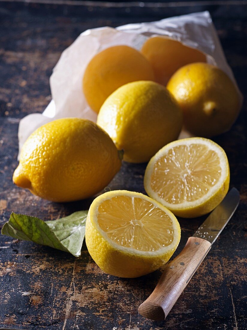 Zitronen in Papiertüte und angeschnitten davor