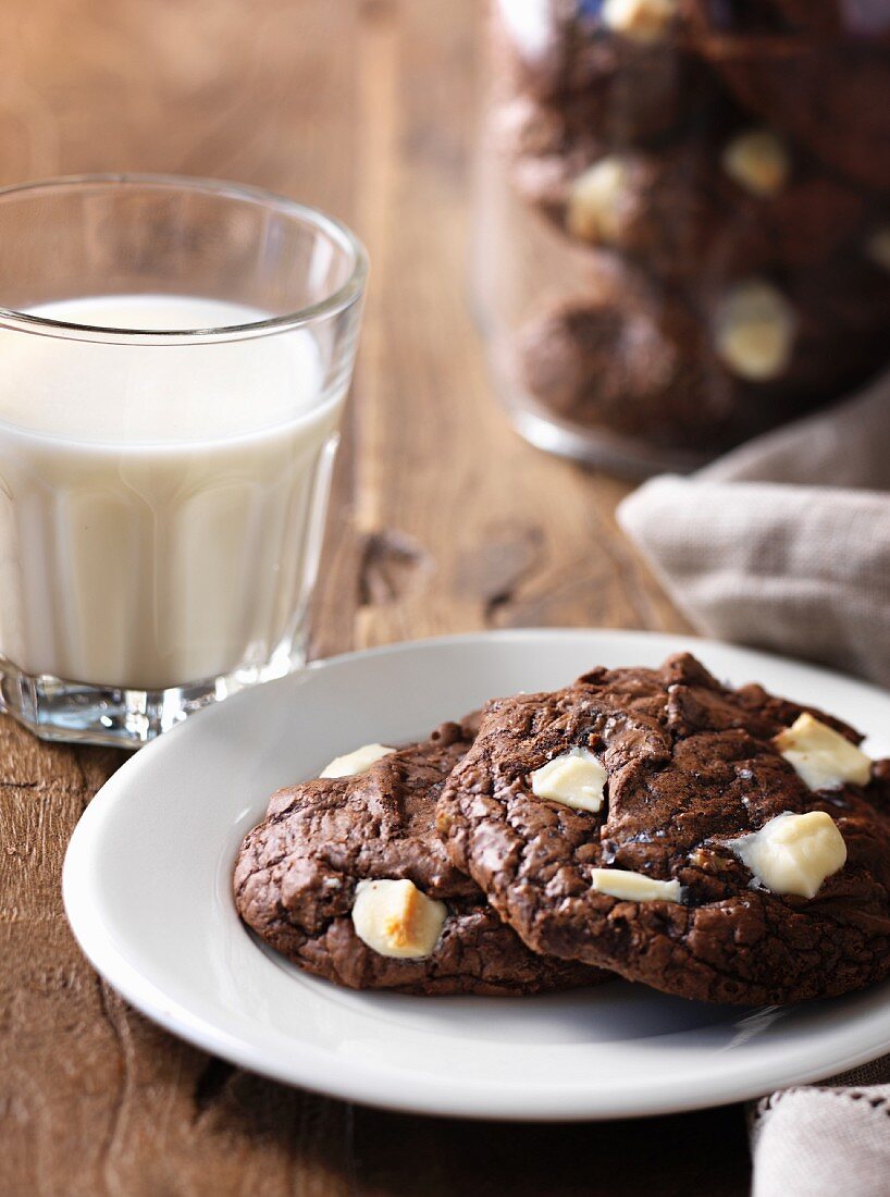 Chocolate cookies with white chocolate chips and a glass of milk