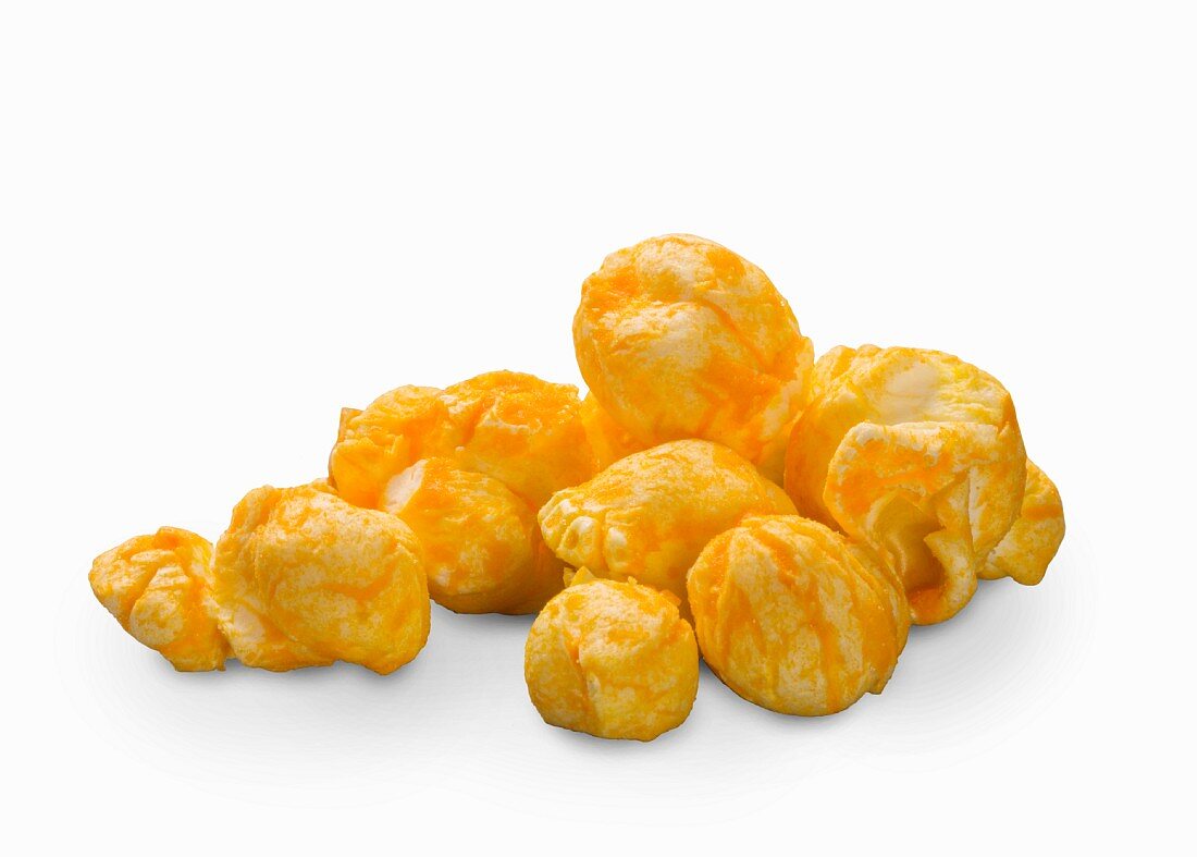 Cheddar popcorn on a white surface (close-up)