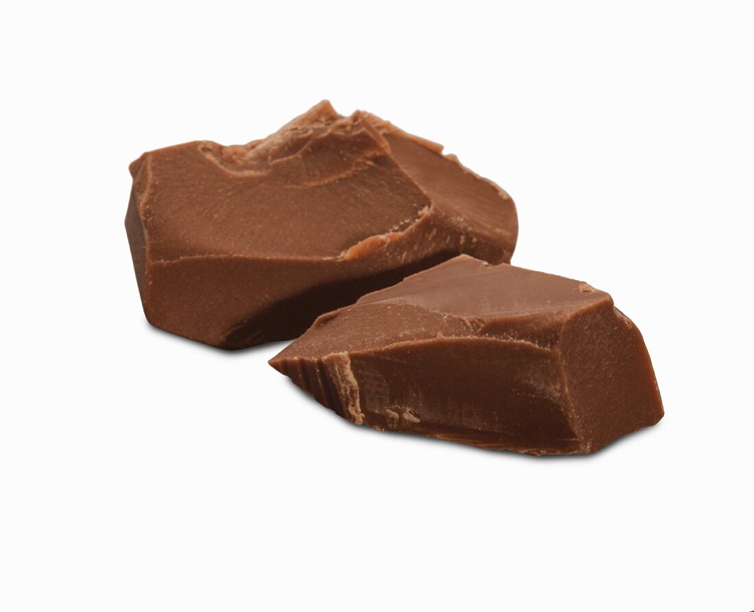 Zwei Schokoladenbrocken vor weißem Hintergrund (Nahaufnahme)
