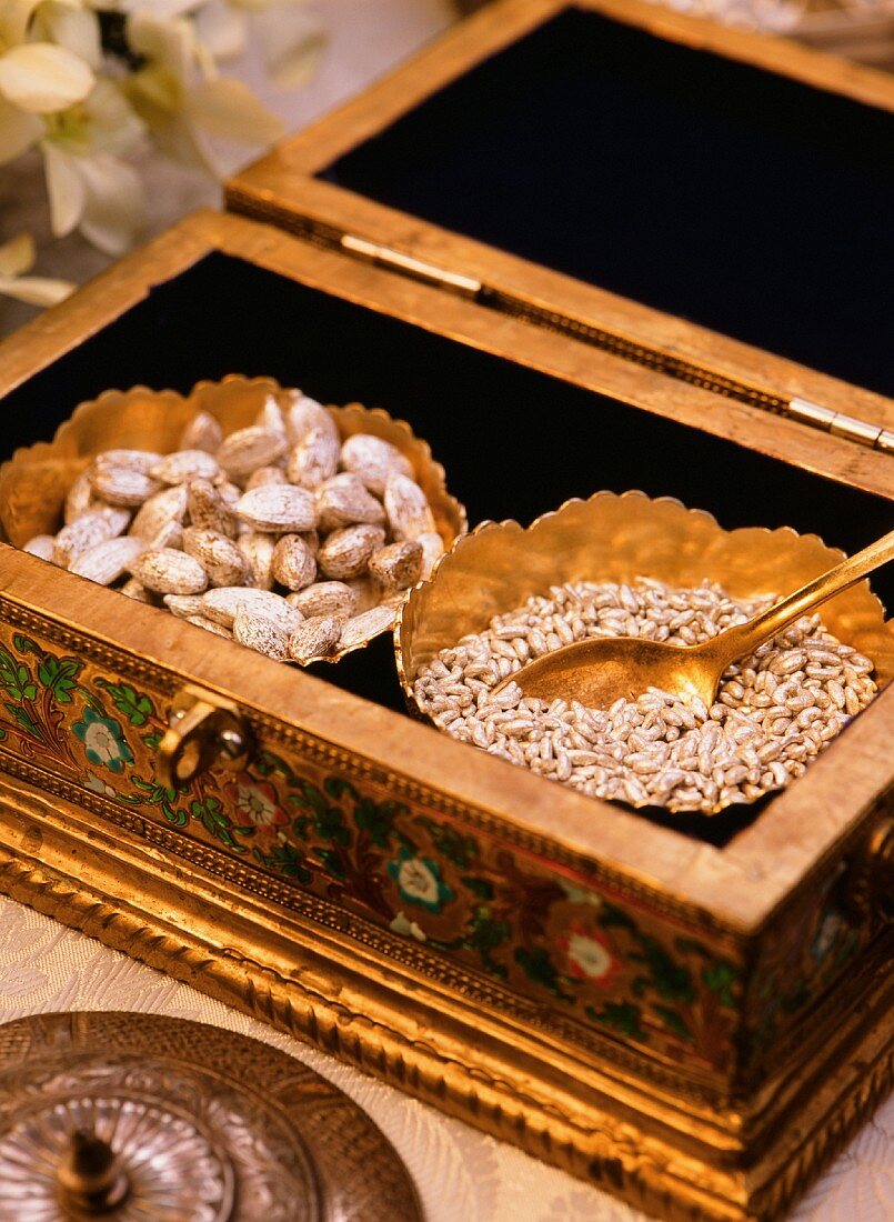 Cardamom pods and pine nuts in a gilded box