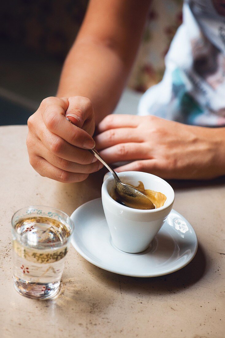 An espresso with a glass of water in Café Famacia, Turin, Italy