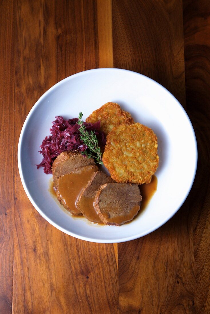 Beef Yankee pot roast with crispy potato fritters and braised red cabbage