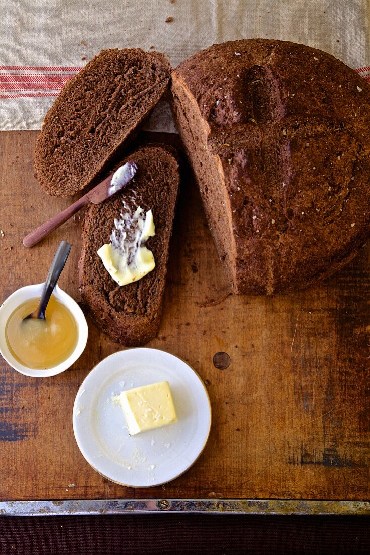 Chocolate bread with butter and honey on a wooden table
