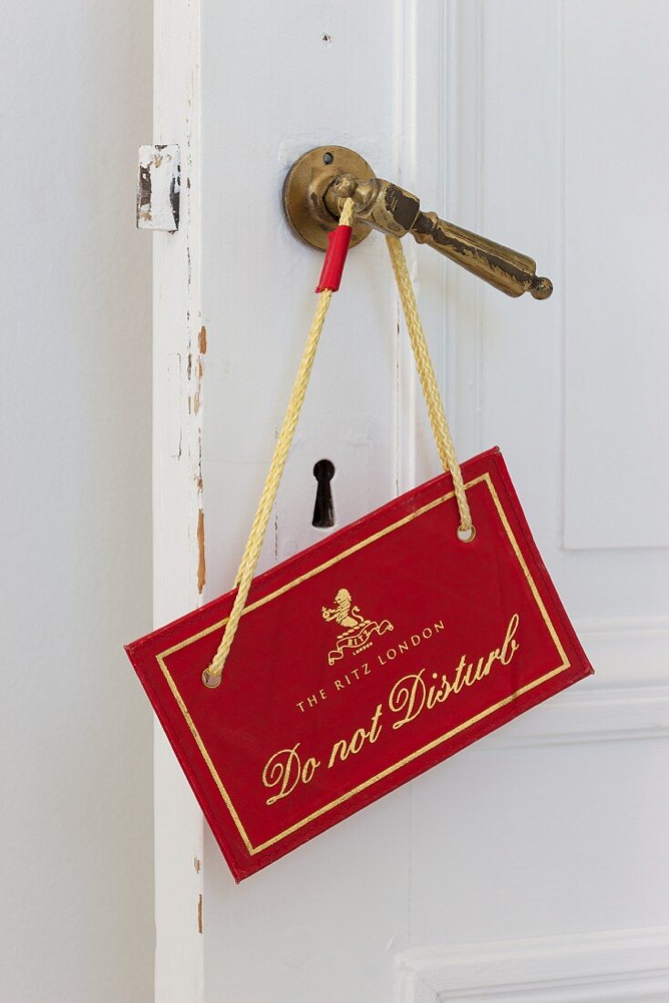 'Do not disturb' sign on traditional brass door handle