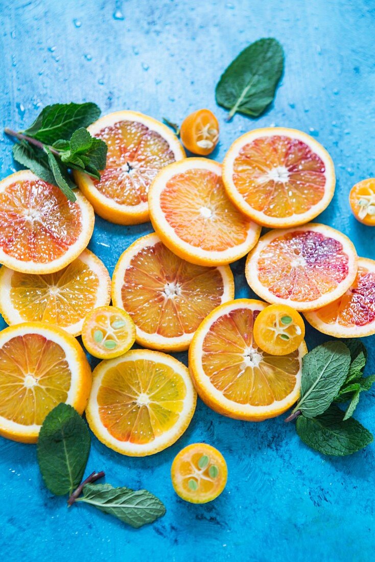 Various citrus fruit slices and fresh mint leaves