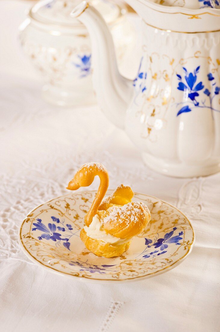 A choux pastry swan with cream and icing sugar