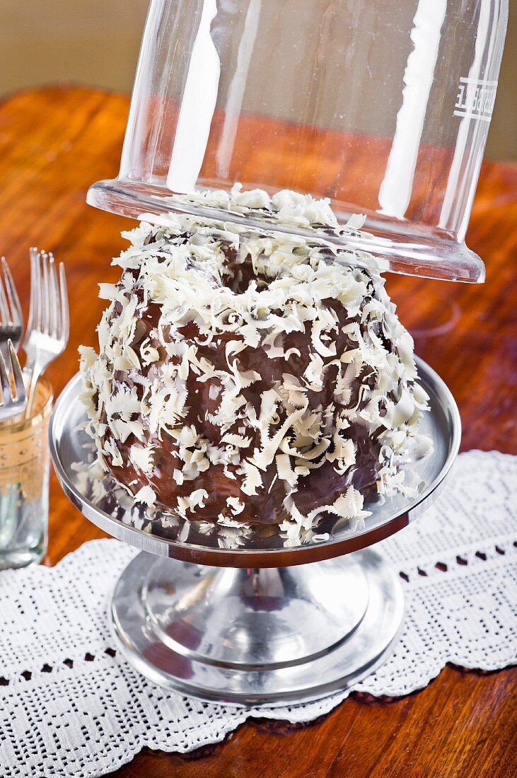 A 'Snow' Bundt cake on a cake with a glass cloche