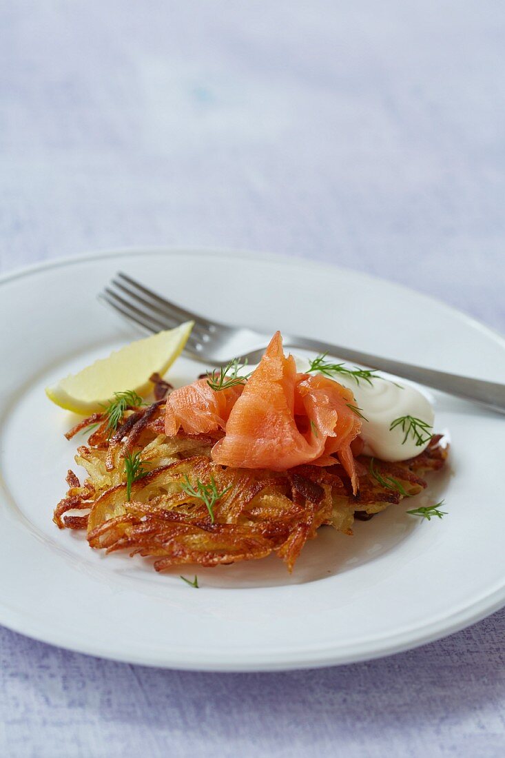 A potato fritter with salmon, crème fraîche and dill