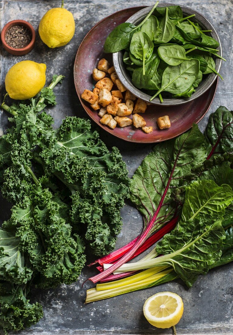 Ingredients for a salad with kale, spinach, chard and croutons
