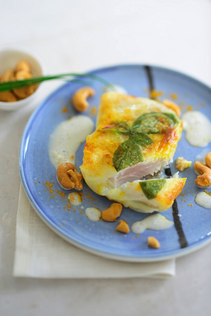 Rotbarsch im Reisblatt mit Kokossauce, Curry und Cashewkernen