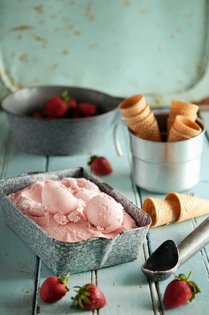 Erdbeereis in Eissschale, Eistüten und Erdbeeren